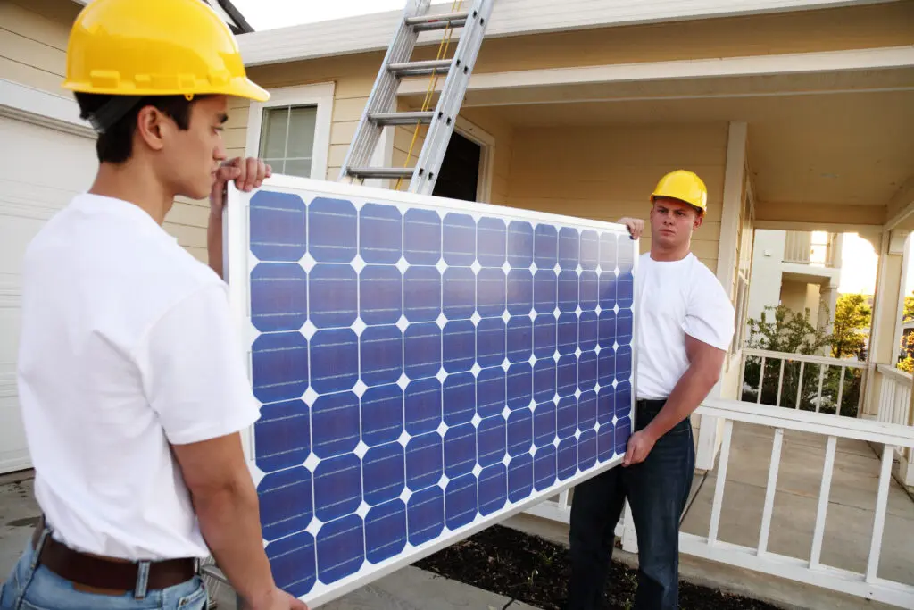 Workmen Carrying A Solar Panel