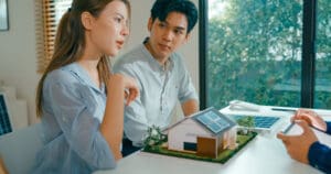 Couple discussing solar powered home model.