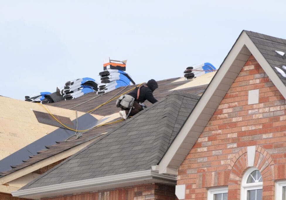 Roofer installing new asphalt shingles