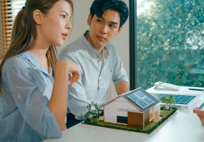 Couple discussing solar powered home model.